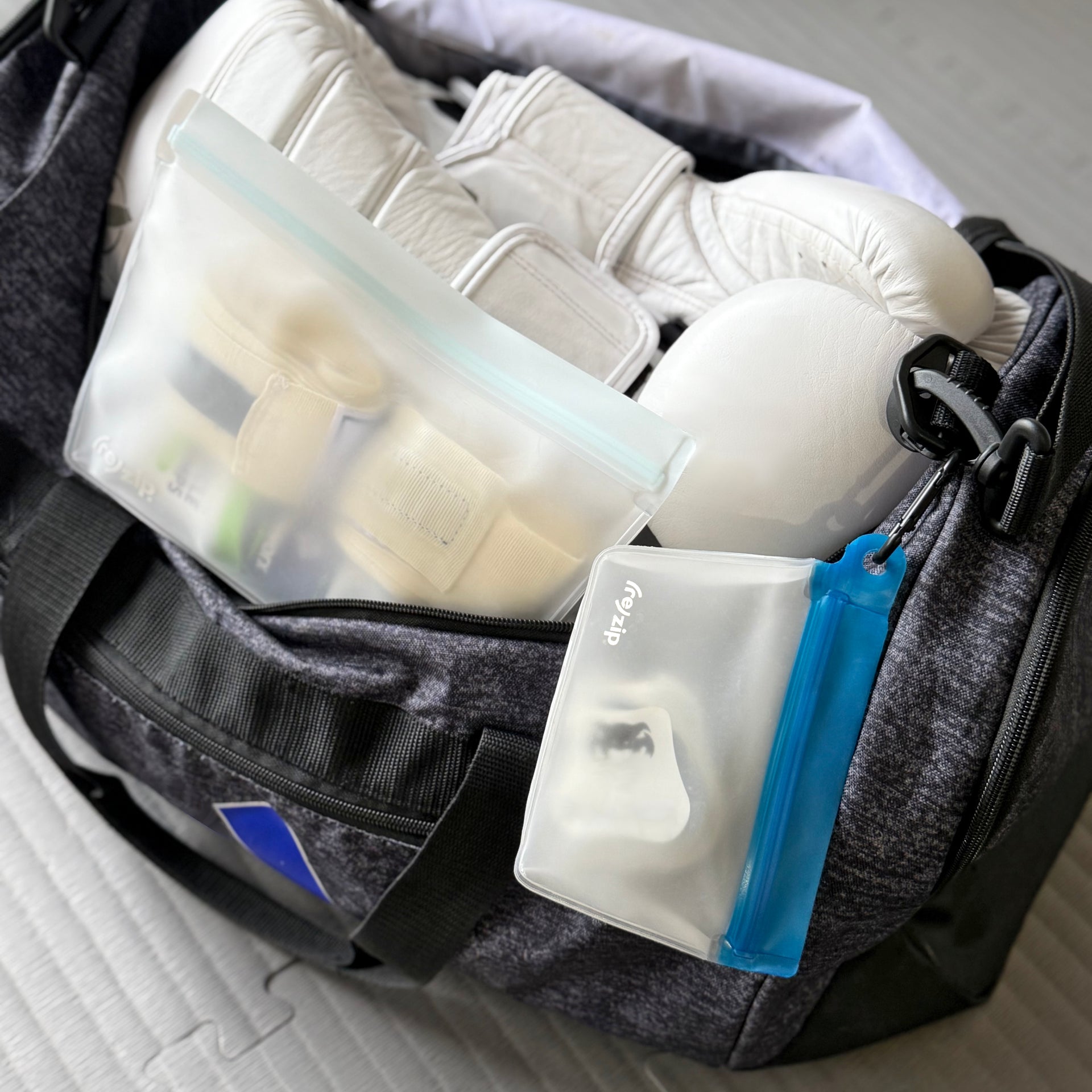 Cobalt blue (re)zip Take Me Too stand-up 1-cup bag with carabiner holding mouth guards – perfect for athletes, school bags, or gym gear organization
