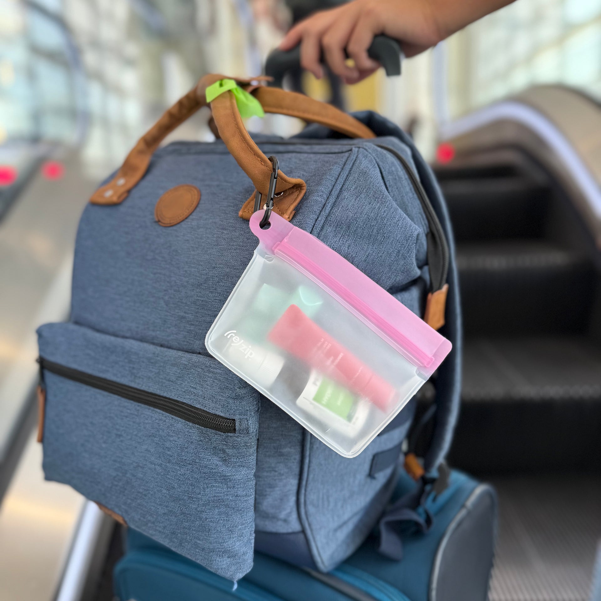 Reusable stand-up travel bag with carabiner clip holding lip balm, hand sanitizer, and lotion – compact, TSA-friendly toiletry storage for on-the-go organization